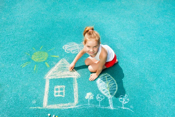 Kleines Mädchen zeichnet Kreidehaus — Stockfoto