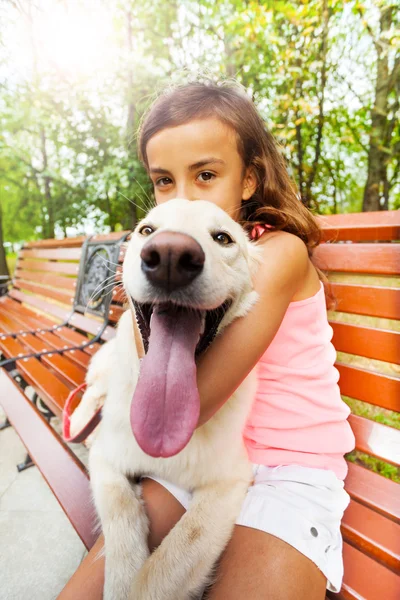 Beautiful teenage girl hugs dog — Stock Photo, Image