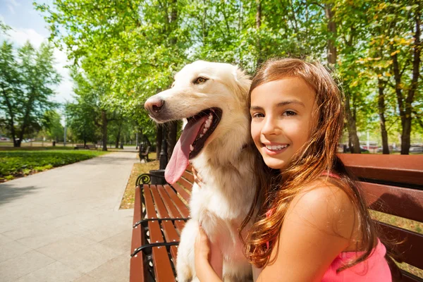 Beautiful teenage girl hugs dog — Stock Photo, Image