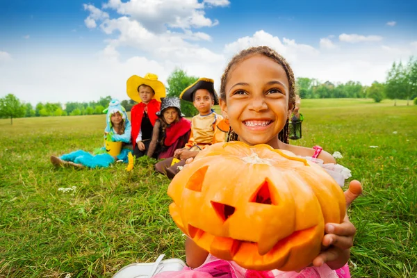 African girl holds Halloween pumpkin — Stock Photo, Image