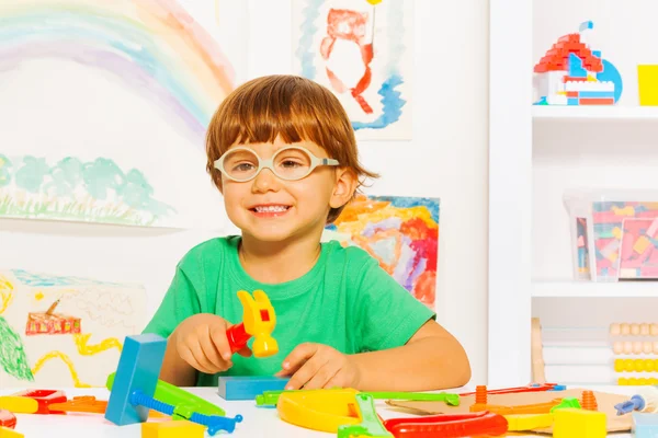 Smart boy in glasses with hammer