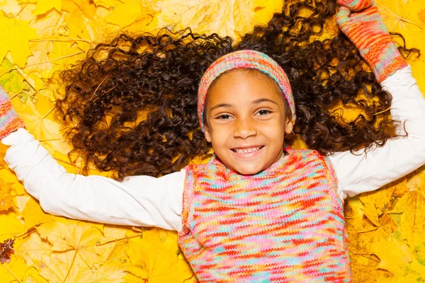 Girl laying on maple leaves — Stock Photo, Image