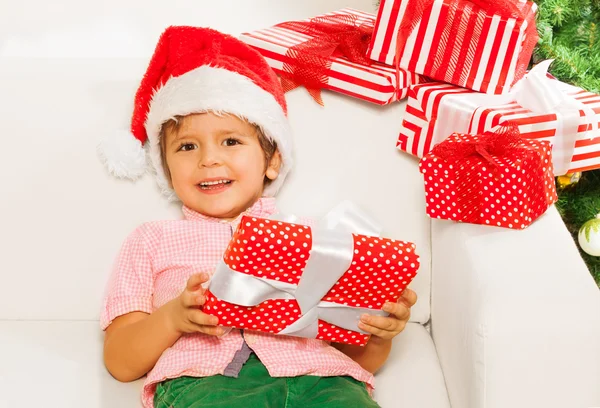 Ragazzo in cappello Babbo Natale con regali — Foto Stock