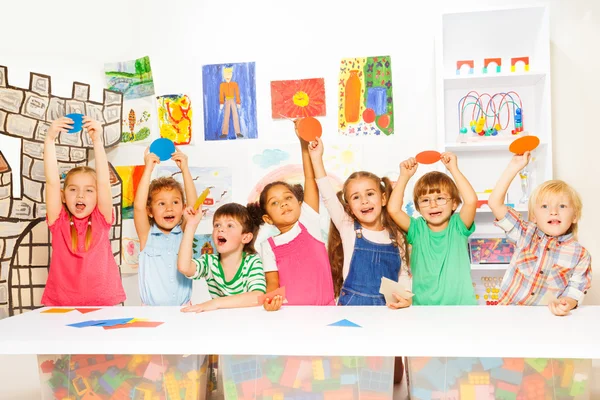Meninos e meninas mostrando formas de papelão — Fotografia de Stock