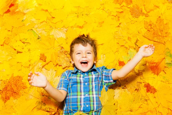 Boy laying in autumn leaves — Stock Photo, Image