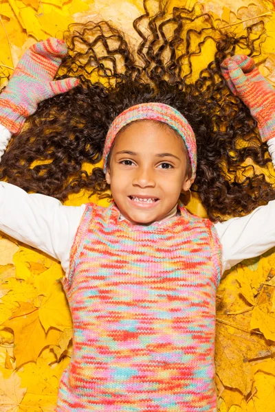 Menina que põe em folhas de bordo — Fotografia de Stock