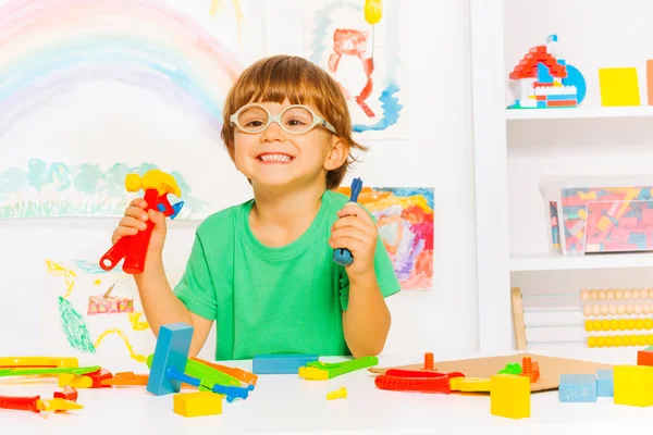 Niño sosteniendo herramientas de plástico — Foto de Stock