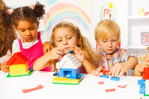 Flickor och en pojke leker med plast block — Stockfoto