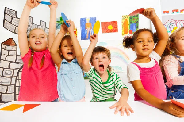 Niños y niñas mostrando formas de cartón — Foto de Stock