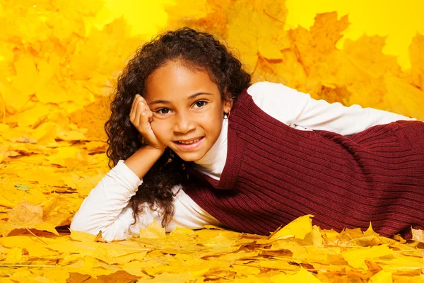 Girl laying on maple leaves — Stock Photo, Image