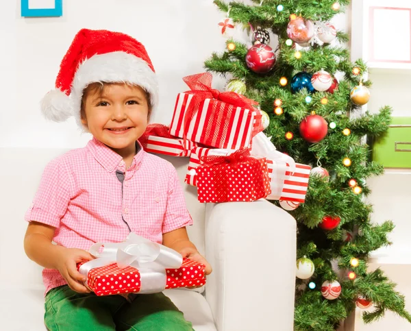 Ragazzo in cappello Babbo Natale con regali — Foto Stock