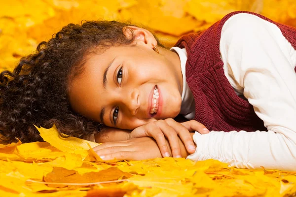 Menina que põe em folhas de bordo — Fotografia de Stock