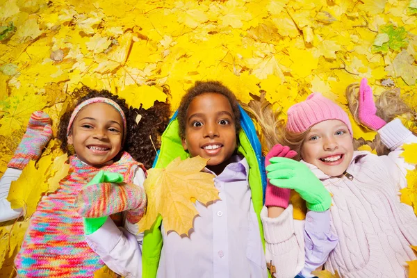 Boy and girls in the autumn leaves — Stock Photo, Image