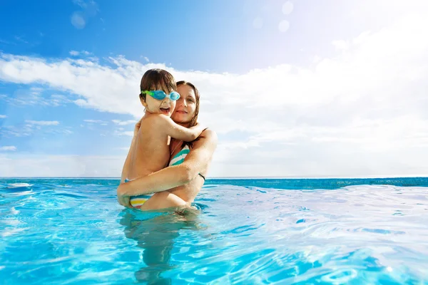 Mother holds son and stands in water — Stock Photo, Image