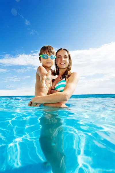 Mère tient son fils et se tient dans l'eau — Photo