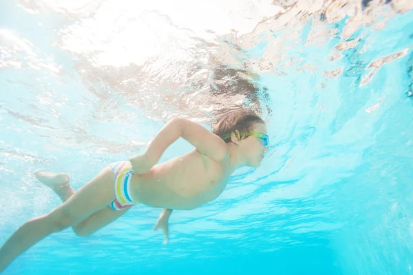 Junge mit Schutzbrille schwimmt unter Wasser — Stockfoto