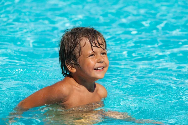 Menino na água da piscina — Fotografia de Stock