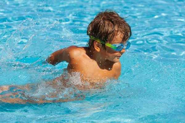 Chłopiec z gogle pływa w basenie — Zdjęcie stockowe