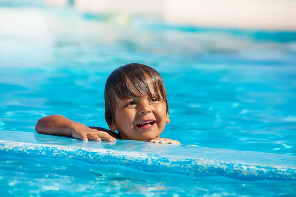 Niño sosteniendo borde de la piscina — Foto de Stock
