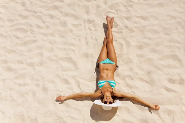 Gebräunte Frau im Bikini auf Sand — Stockfoto