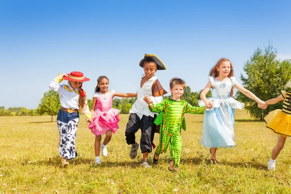 Crianças felizes correndo vestindo trajes — Fotografia de Stock