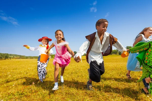 Crianças felizes correndo vestindo trajes — Fotografia de Stock