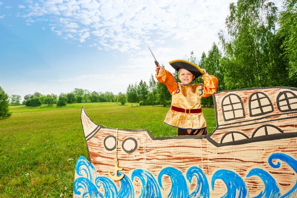 Boy stands on ship with sword — Stock Photo, Image