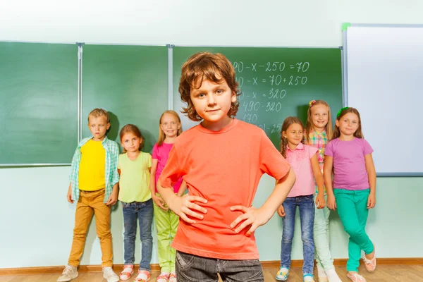 Jongen staat voor kinderen — Stockfoto