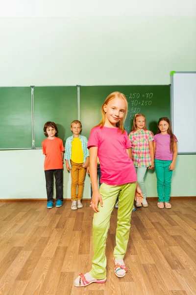 Girl stands in front of kids — Stock Photo, Image