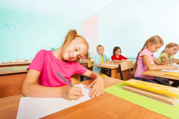 Les enfants écrivent dans des cahiers — Photo