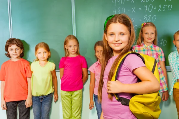 Meisje staat in de buurt van blackboard — Stockfoto