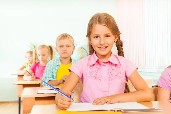 Girl writing in exercise book — Stock Photo, Image