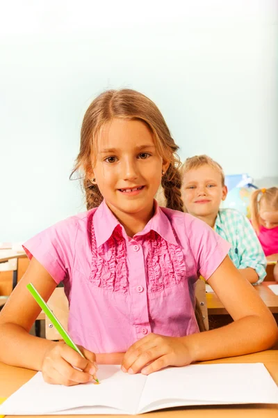 Mädchen sitzt am Schreibtisch im Klassenzimmer — Stockfoto