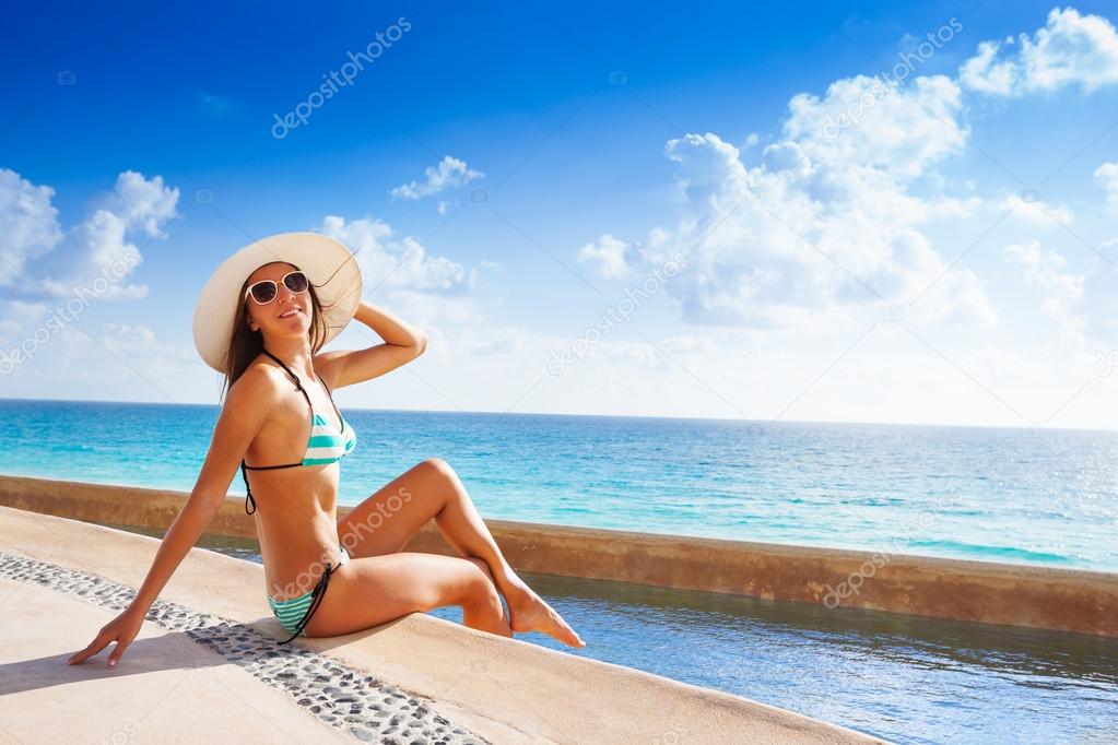 Woman in white hat on stone pier