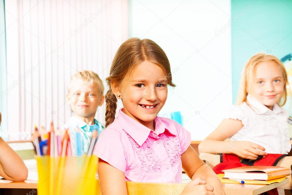 Girl and pupils sitting at desks