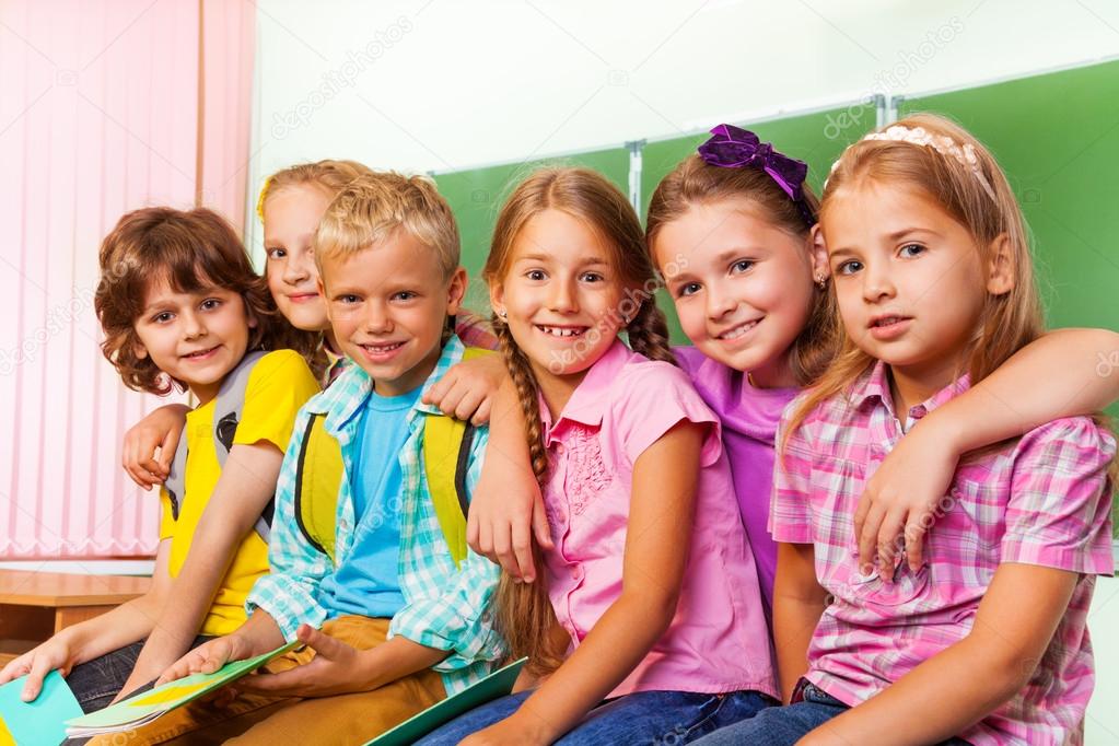 Group of children stand and hug