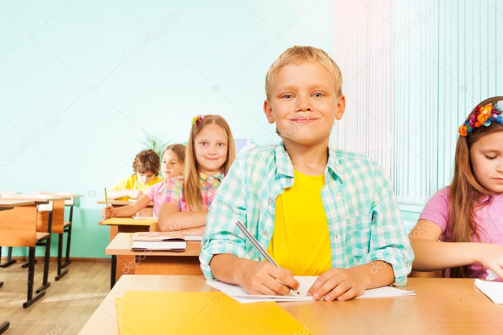 Smiling boy sits in class