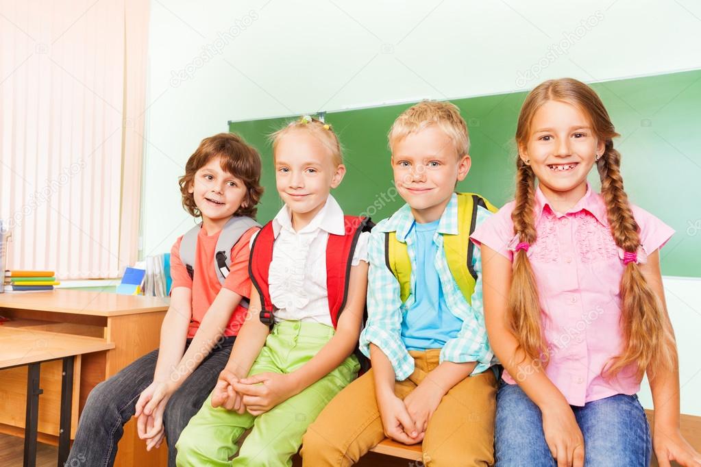 Schoolchildren sitting near desk
