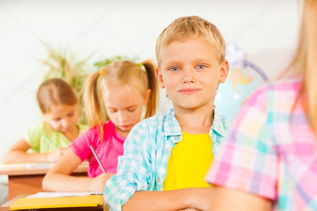 Boy in classroom with other pupils