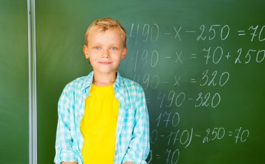 Blackboard yakınındaki parlak T-shirt çocukta