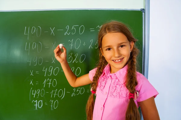 Chica escribiendo ecuación matemática — Foto de Stock