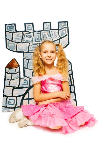 Meisje zit in de buurt van kartonnen kasteel — Stockfoto