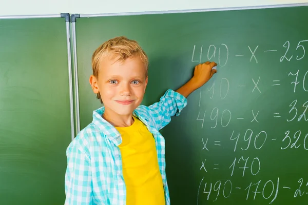 Niño con tiza durante la lección de matemáticas Imágenes De Stock Sin Royalties Gratis