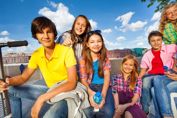 Friends sitting on chairs of embankment — Stock Photo, Image