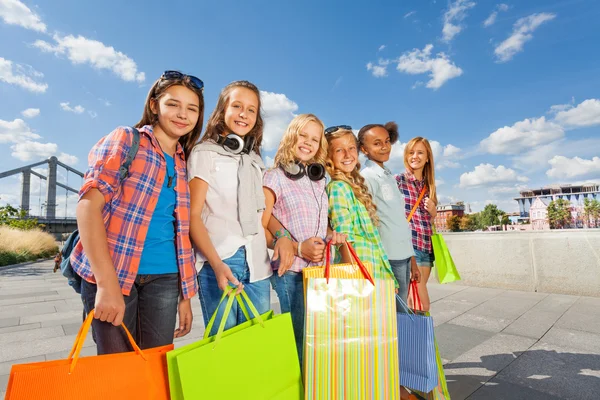 Piger med shopping poser gå sammen - Stock-foto