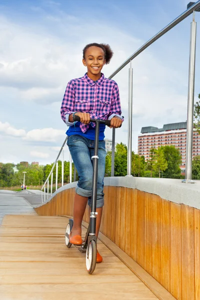 Menina Africano equitação scooter — Fotografia de Stock