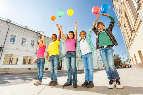 Niños de pie con globos de colores —  Fotos de Stock