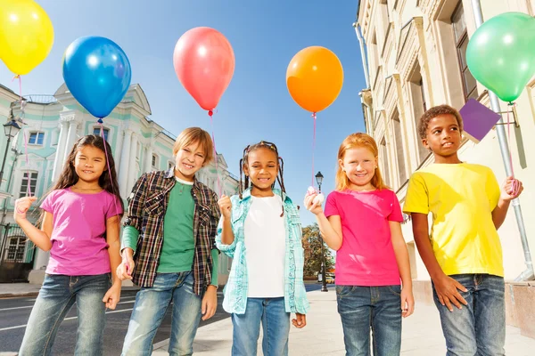 Niños de pie con globos de colores — Foto de Stock