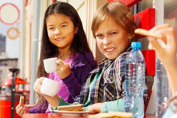 Internationella barnen sitter i café — Stockfoto