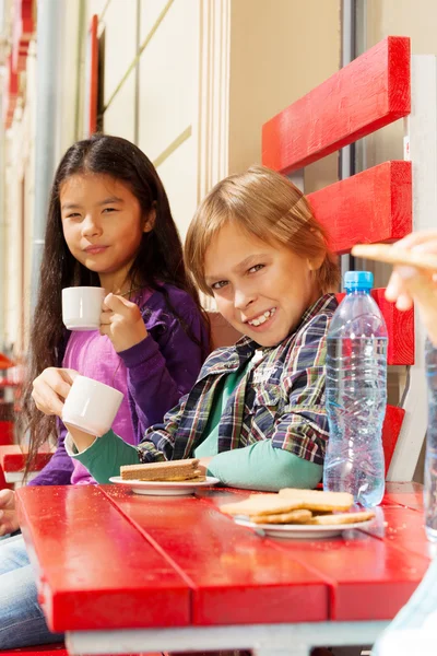 Internationella barnen sitter i café — Stockfoto